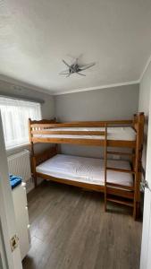 卡纳芬Chalet 130 on Glan Gwna holiday park的客房设有两张双层床和吊扇。