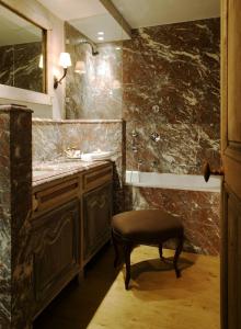 布鲁日勃艮第克罗伊斯酒店的浴室设有水槽和镜子旁的凳子