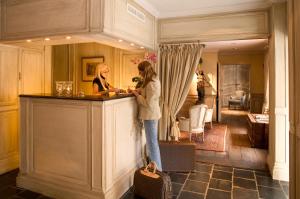 布鲁日勃艮第克罗伊斯酒店的两名妇女站在房间里柜台