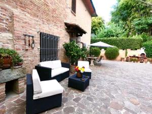 锡耶纳Casa Lazzaro al centro di Siena的砖砌建筑中一个带沙发和椅子的庭院