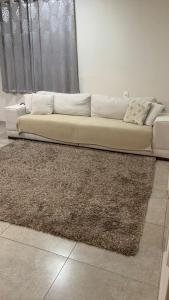 本图贡萨尔维斯Dom Ângelo Hospedagem的客厅里一张白色沙发,铺着地毯