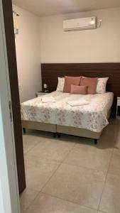 本图贡萨尔维斯Dom Ângelo Hospedagem的一间卧室配有带粉红色枕头的床。