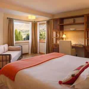 圣马丁德洛斯卡索纳德尔奥拓酒店的一间卧室配有一张床、一张书桌和一个窗户。