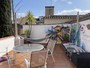 格拉纳达El Granado Hostel的一个带桌椅和壁画的庭院