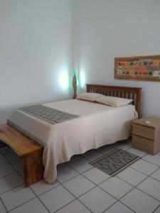 塔曼达雷CASA DA NINA的卧室配有一张白色的大床和一张桌子