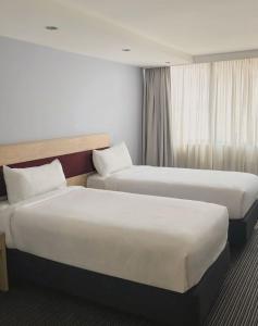 悉尼Central Studio Hotel Sydney的酒店客房设有两张床和窗户。