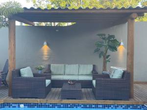 欧纳波利斯Pousada Macdonald的一个带沙发和桌子的庭院,毗邻一个游泳池