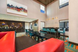 佩里贝斯特韦斯特布拉德伯里旅馆&套房酒店的一间设有红色桌椅的餐厅和一间酒吧
