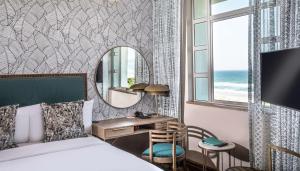 德班Suncoast Hotel & Towers的一间卧室配有一张床、一张书桌和一面镜子