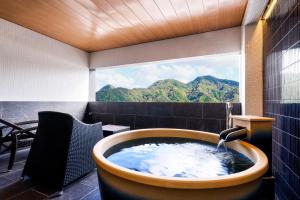 丰冈市川口屋城崎河滨酒店的窗户客房内的浴缸