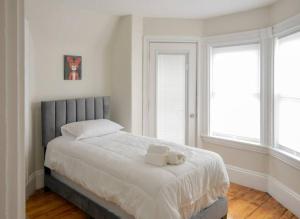 波士顿Boston Historical Urban Oasis的一间卧室配有一张床,上面有两条毛巾