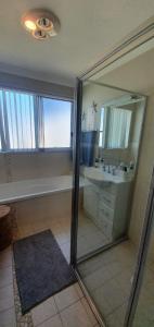 St Georges BasinDiscover St Georges Basin的带淋浴、盥洗盆和镜子的浴室