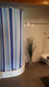 Le Noirmontschöner Aufenthalt的浴室配有蓝色的浴帘和卫生间