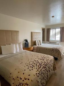 摩押The Virginian Inn Moab Downtown的酒店客房设有两张床和窗户。