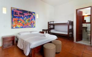 卡塔赫纳Casa Pedro Romero的卧室配有一张床,墙上挂有绘画作品