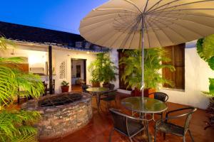 卡塔赫纳Casa Pedro Romero的一个带桌椅和遮阳伞的庭院