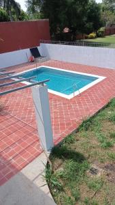 AreguáCasa de la Amistad的红砖地板上的小型游泳池