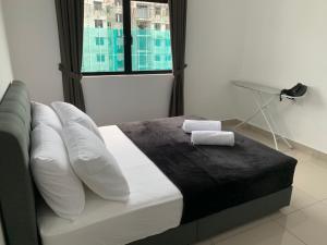 迪沙鲁Desaru Utama Apartment with Swimming Pool View, Karaoke, FREE WIFI, Netflix, near to Car Park的卧室配有带枕头的床铺和窗户。