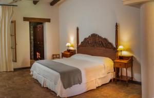 卡法亚特Finca El Recreo的一间卧室配有一张大床、一张桌子和台灯。