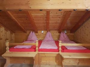 KüblisFerienhaus Stutz Hausteil links的配有红色靠垫的桑拿浴室内的两张床