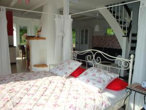 RakowHaus Dornröschen的卧室配有带红色枕头的白色床