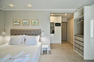 瓦尔纳Sea lounge的一间带白色大床的卧室和一间厨房
