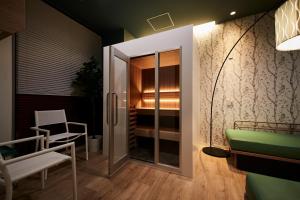 京都MONday Apart Premium KYOTO Station的一间设有滑动玻璃门和椅子的房间