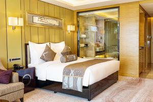 无锡无锡新湖铂尔曼大酒店的酒店客房设有一张大床和一张沙发。
