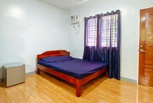 BanhiganIrah's Guest House的一间卧室,在房间内配有一张紫色的床