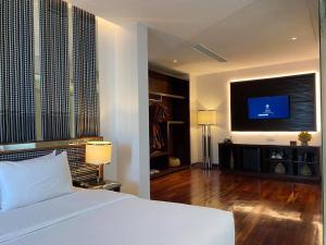 暹粒UTEY Hotel的一间卧室配有一张床和一台平面电视