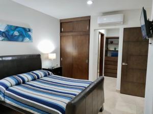 马萨特兰Brujas Tower Beach Resort的一间卧室配有一张带蓝白条纹毯子的床