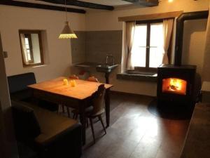 波斯基亚沃Sunny, rustical 5 room cottage in Valposchiavo的客厅配有木桌和燃木炉。