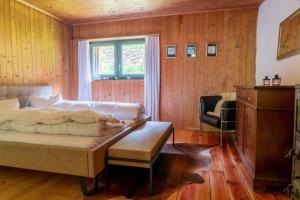 波斯基亚沃Sunny, rustical 5 room cottage in Valposchiavo的卧室配有床、椅子和窗户。