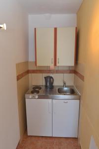 蒂瓦特Apartments Palace Mira Mare的小厨房配有白色橱柜和水槽