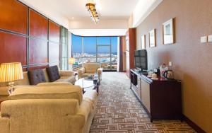 昆明昆明世纪金源大饭店的一间客厅,客厅配有沙发和电视,位于酒店的房间