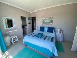 杰弗里湾Grys Patrys - 4 Beds Beach Home的卧室配有蓝色的床,墙上配有电视
