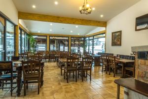 博希尼博因吉斯克杰兹洛酒店的餐厅设有木桌、椅子和窗户。