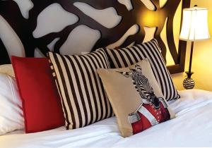 哈博罗内Waterside Cottages的一张带两个枕头的床,上面有斑马