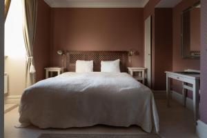 马斯特兰德马斯特兰格兰德酒店的卧室配有白色的床、两张桌子和一扇窗户