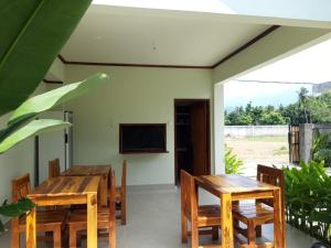 塞隆贝拉纳克kamala的一间带木桌、椅子和电视的用餐室