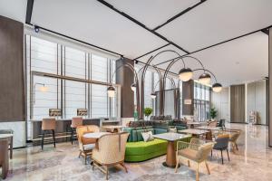 深圳深圳南山科技园希尔顿惠庭酒店的大堂设有绿色的沙发和桌椅