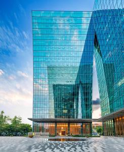 深圳深圳南山科技园希尔顿惠庭酒店的一座高大的玻璃建筑,有很多窗户