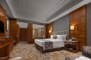 长沙湖南佳兴世尊酒店的酒店客房,配有床和电视