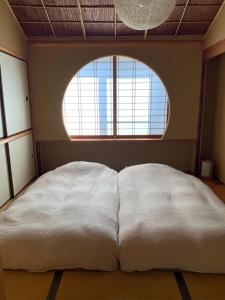 武雄市unsui 武雄蓬莱町 雲水的窗户客房内的一张大白色床