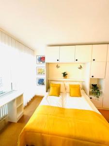 上施陶芬Mountains–Allgäu Living – 40sqm的一间卧室配有黄色的大床和黄色枕头