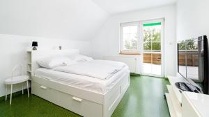 梅斯瓦科维采Apartamenty Sun & Snow Villa Sportowa的白色卧室设有白色的床,铺有绿色地板。