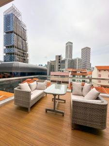 新加坡D'Nova Hotel Bugis的大楼内的阳台配有两张沙发和一张桌子