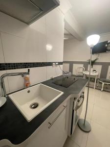 Deuil-la-BarreChambre de luxe 95 Grise的浴室设有水槽和台面上的灯