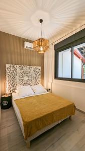 埃唐萨莱莱班海滩Villa des 3 sables, CAPUCIN的一间卧室配有一张大床和一个吊灯。