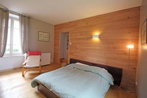 GlandonLe gueraudier的一间卧室设有一张床和木墙